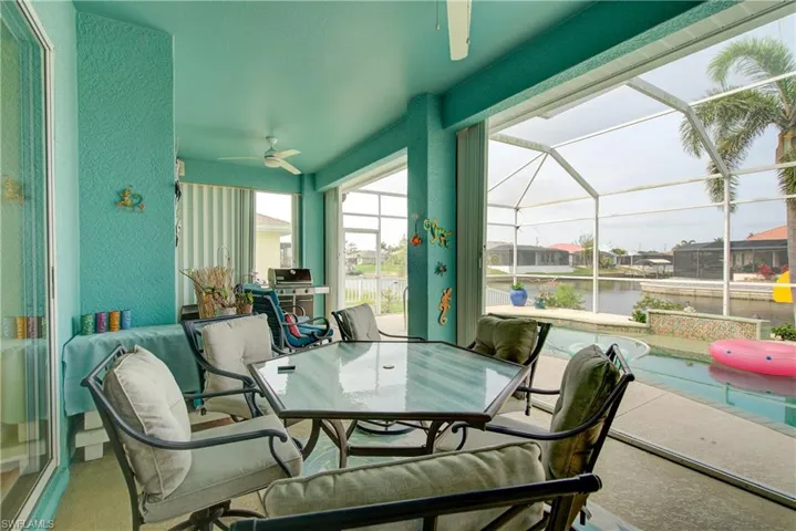Sunroom / solarium featuring a water view, ceiling fan, and outdoor dining area