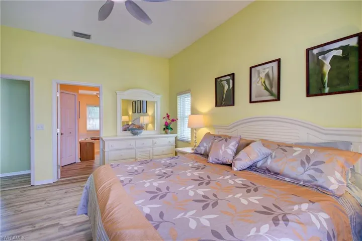 Bedroom with baseboards, visible vents, light wood-style floors, and ceiling fan