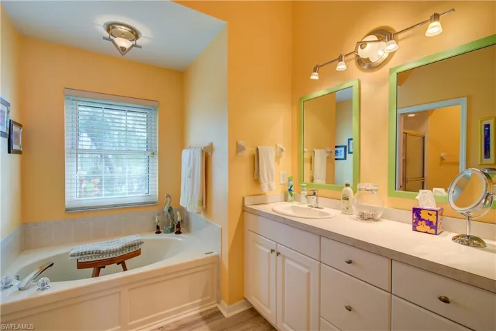Bathroom featuring a bath, a stall shower, and vanity