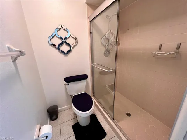 Full bath featuring a shower stall and light tile patterned floors