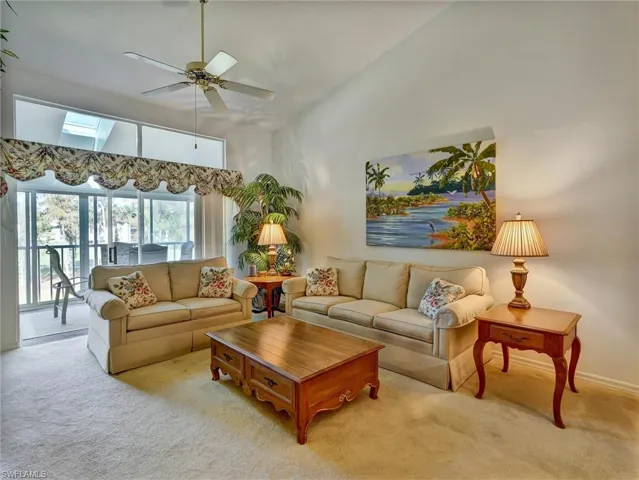 Living room featuring carpet, a skylight, and ceiling fan