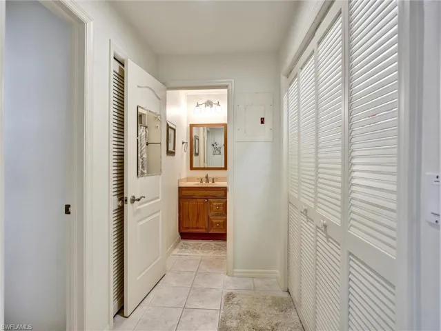 Corridor with light tile patterned flooring and electric panel