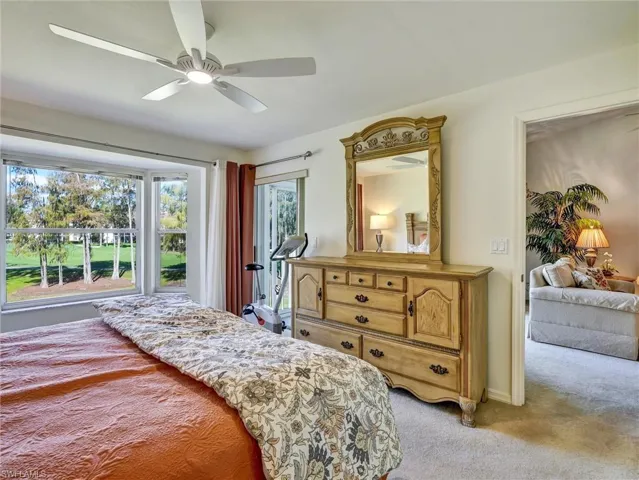 Bedroom with light carpet and a ceiling fan