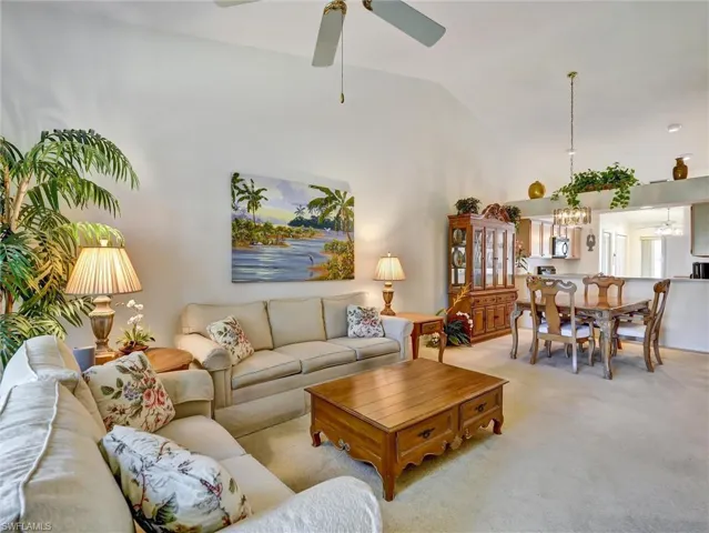 Living room featuring carpet, high vaulted ceiling, and a ceiling fan