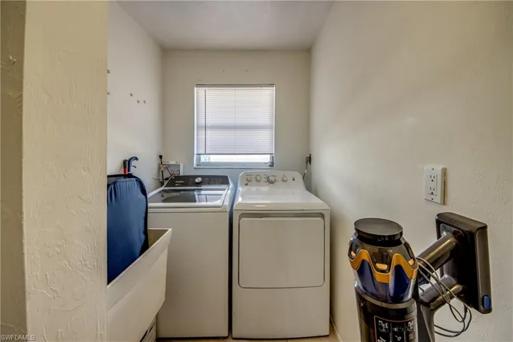 Washroom featuring washer and dryer and a textured wall