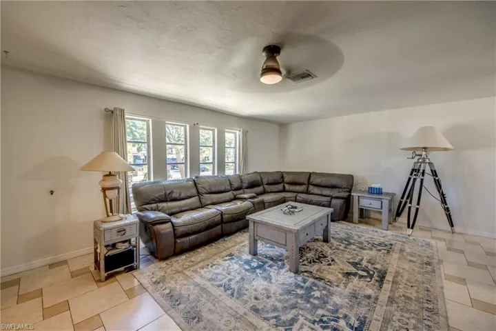 Living area with baseboards and ceiling fan