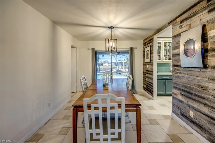 Dining space featuring a chandelier and wooden walls