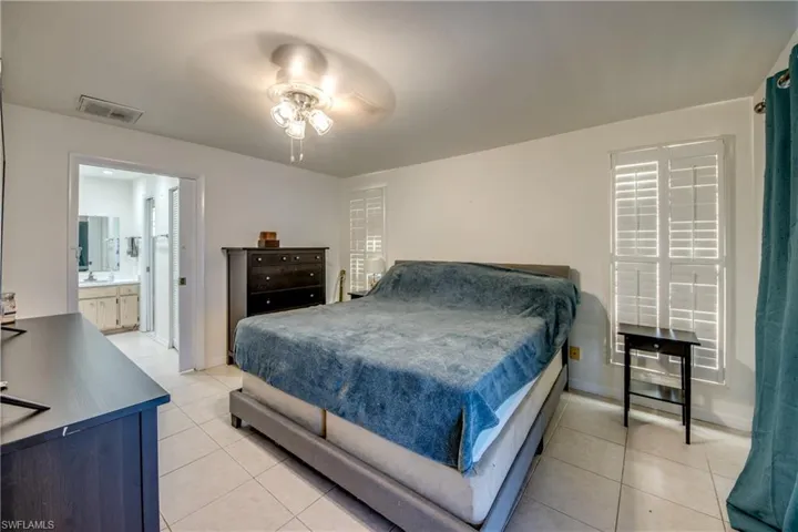 Bedroom featuring light tile patterned floors and a ceiling fan