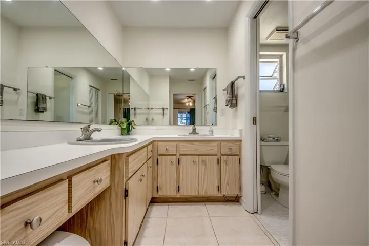 Bathroom featuring double vanity, light tile patterned floors, ceiling fan, and recessed lighting