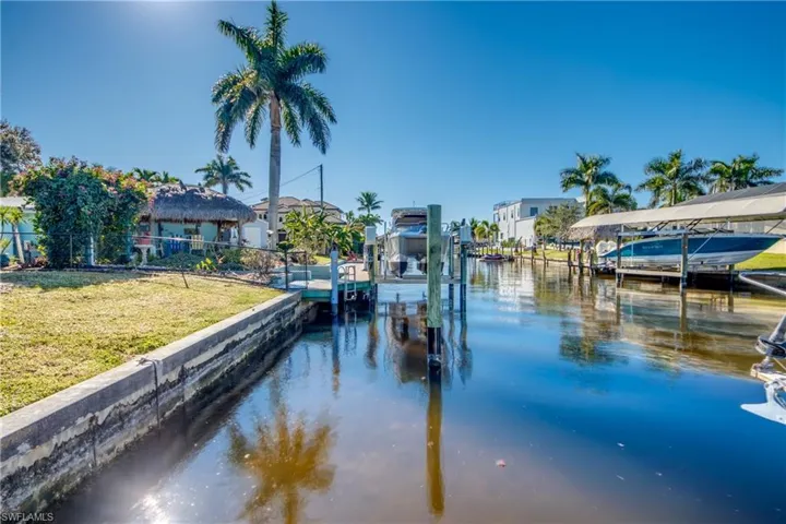 Dock area featuring a water view, boat lift, and a residential view