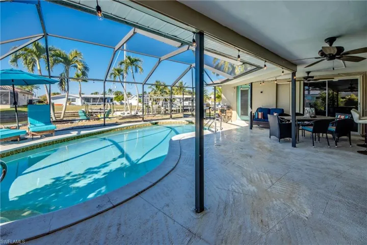 Swimming pool with a lanai, a patio, a sunroom, and outdoor dining area
