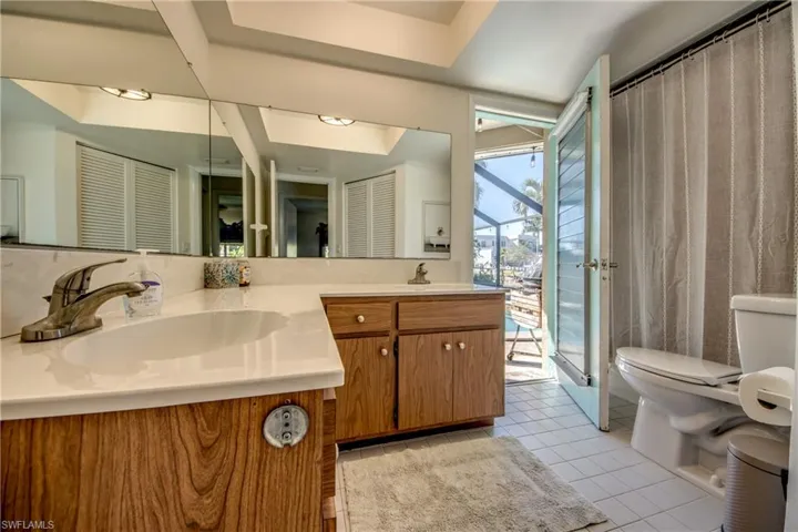Full bathroom featuring a closet, double vanity, light tile patterned flooring, and a shower with curtain