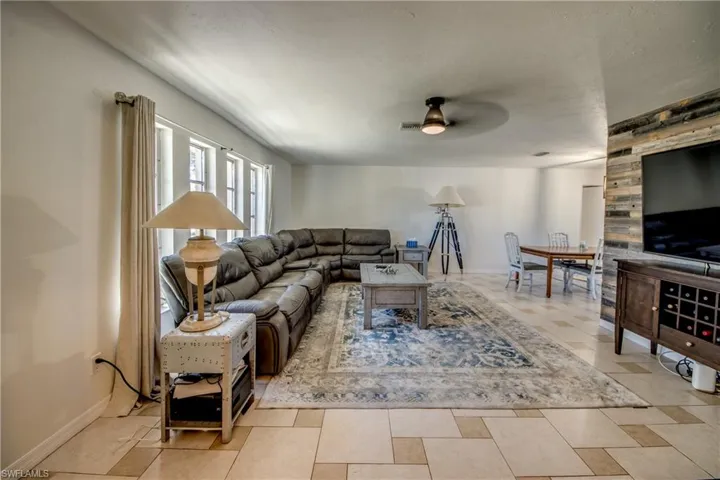 Living area featuring baseboards and ceiling fan
