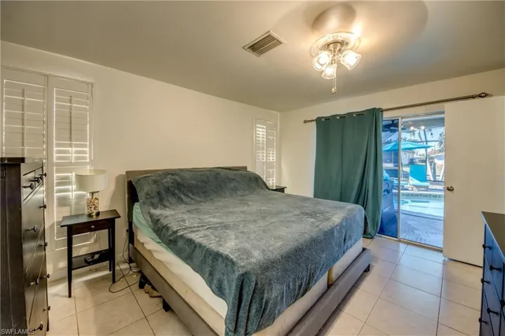 Bedroom featuring access to exterior, a ceiling fan, and light tile patterned floors