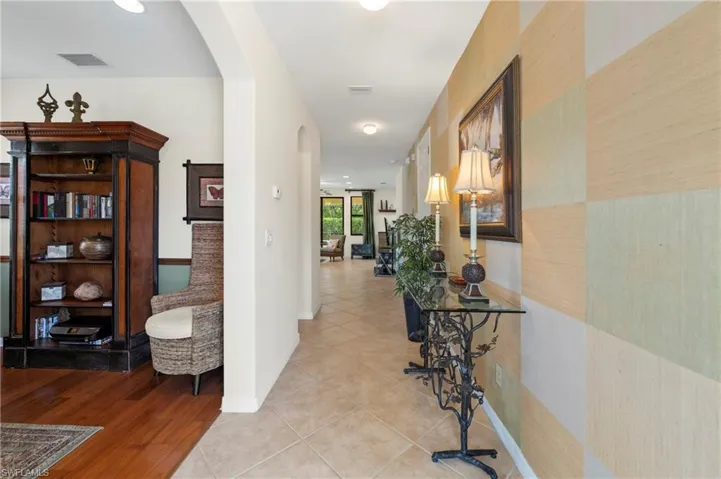 Hallway featuring tiled flooring, recessed lighting, and arched doorways