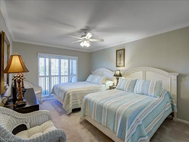 Bedroom with carpet floors, crown molding, and a ceiling fan