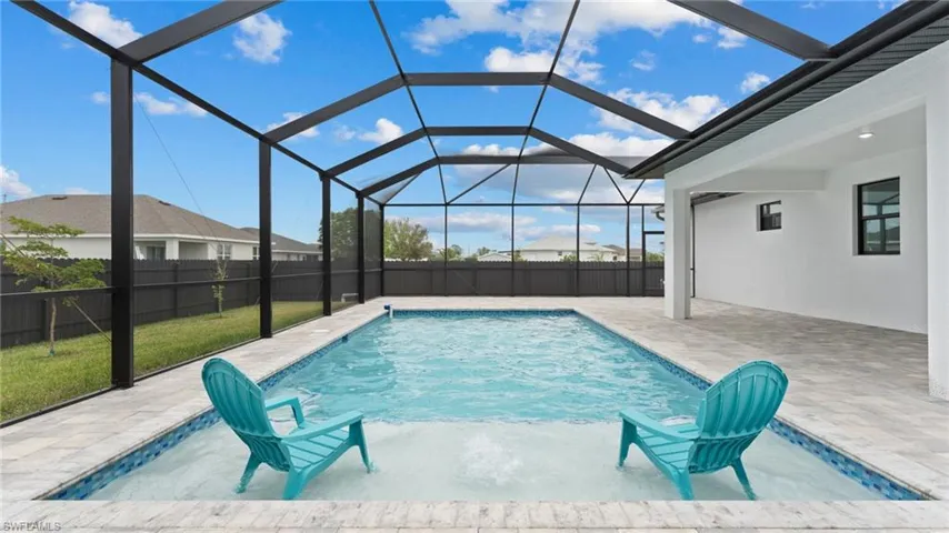 View of swimming pool with a patio and glass enclosure