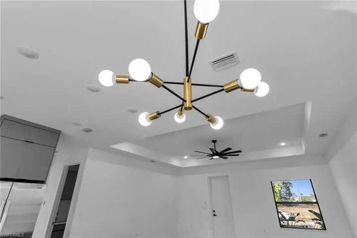 Detailed view of a raised ceiling, ceiling fan, and recessed lighting