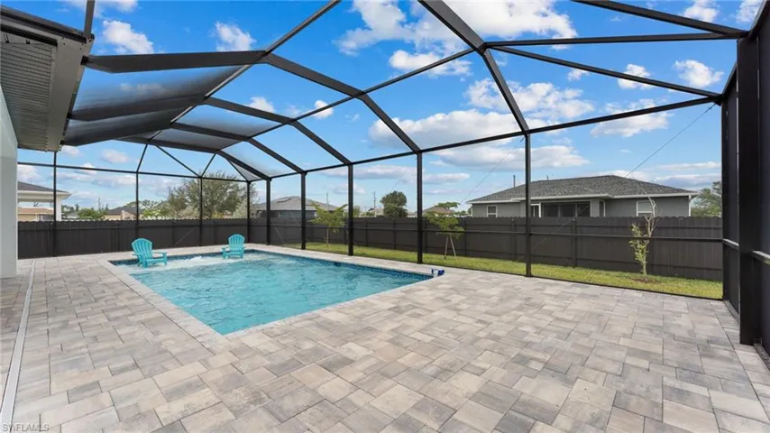 View of swimming pool with a patio, a fenced backyard, and glass enclosure