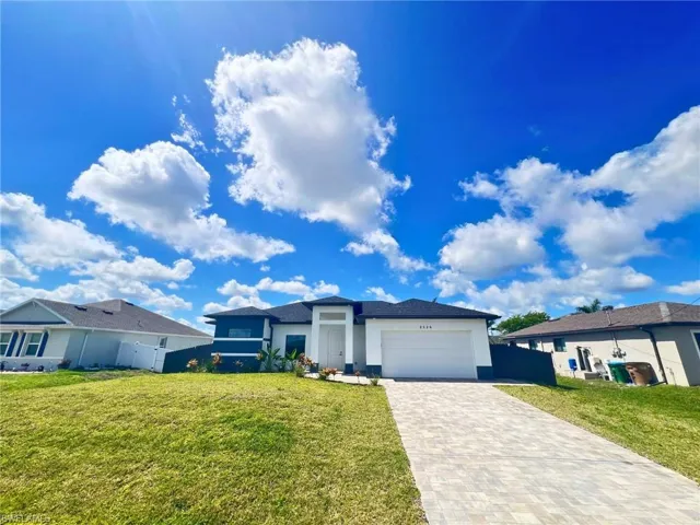 View of front of property featuring decorative driveway, stucco siding, and an attached garage