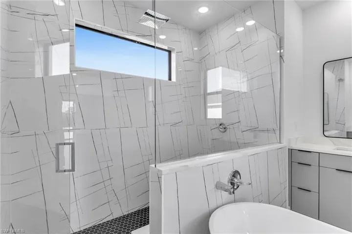 Full bathroom featuring a stall shower, a freestanding tub, and vanity