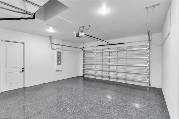 Garage featuring electric panel and a garage door opener