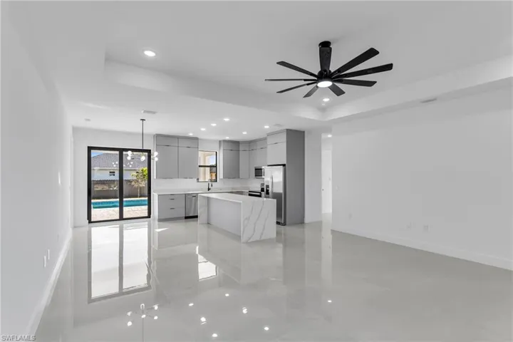 Kitchen featuring appliances with stainless steel finishes, modern cabinets, gray cabinets, a tray ceiling, and recessed lighting