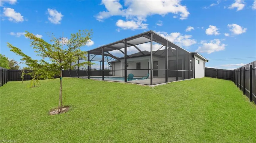 Back of property with glass enclosure and a patio area