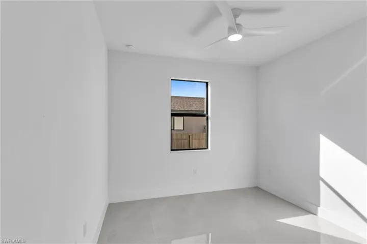 Unfurnished room featuring a ceiling fan, baseboards, and light tile patterned flooring
