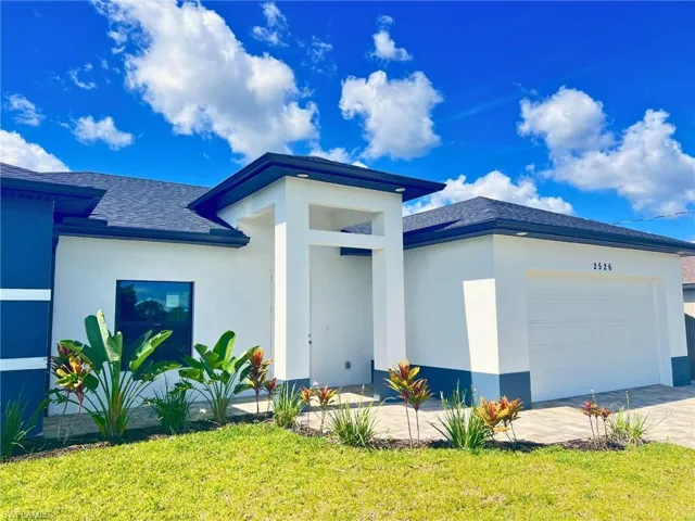 View of front of property with an attached garage, stucco siding, and roof with shingles