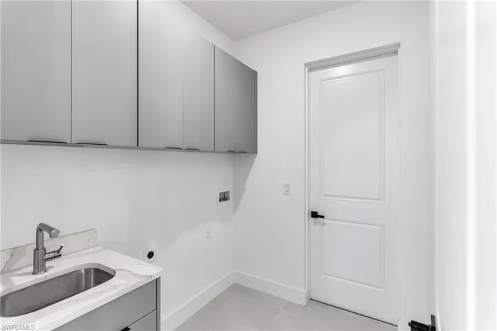 Laundry area featuring cabinet space, washer hookup, electric dryer hookup, and baseboards