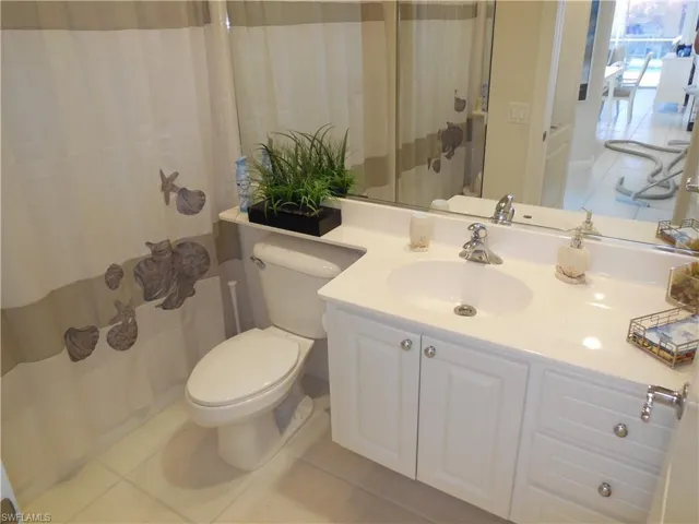 Bathroom with tile floors, oversized vanity, and toilet