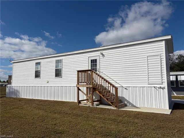 Back of property featuring a lawn