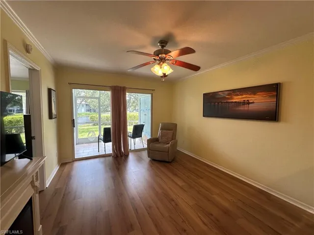 Unfurnished room with ceiling fan, crown molding, and dark wood-type flooring