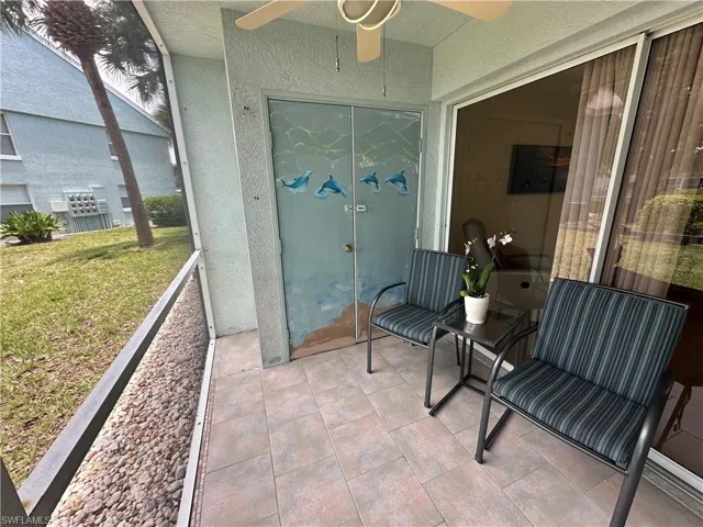 Entrance to property with ceiling fan, a lawn, and a patio area