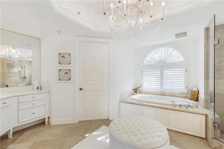 Bathroom featuring tile patterned flooring, a notable chandelier, ornamental molding, and shower with separate bathtub
