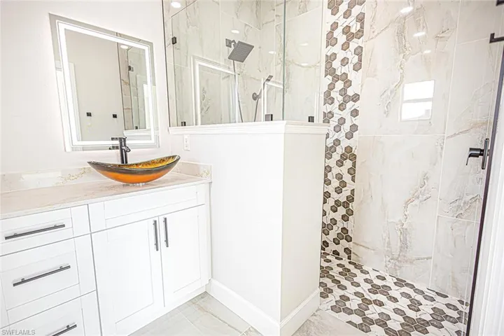 Bathroom with tiled shower and vanity