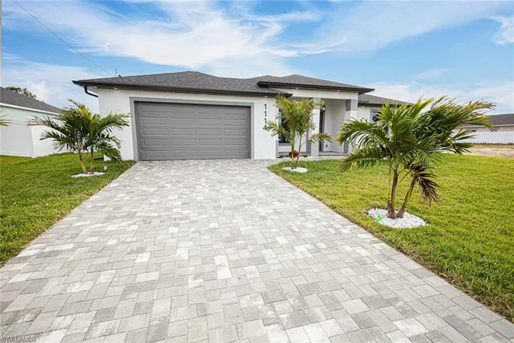View of front of home featuring a garage and a front lawn