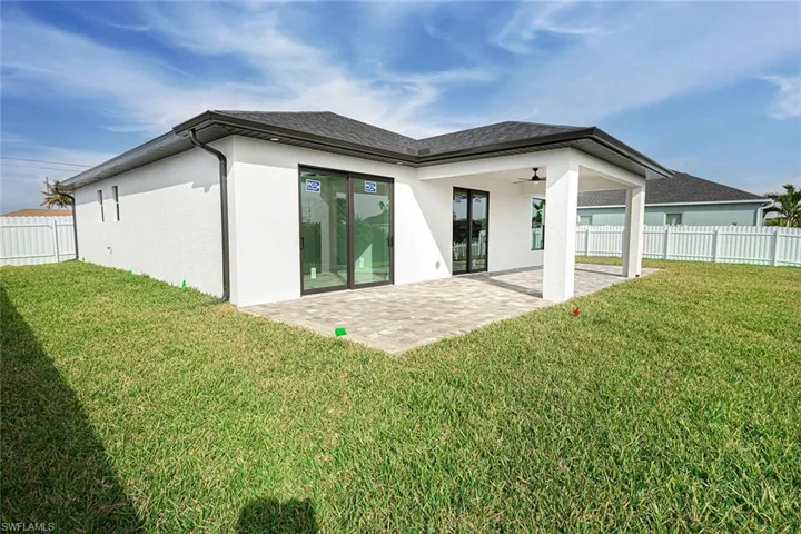 Rear view of property featuring a yard, a patio, and ceiling fan