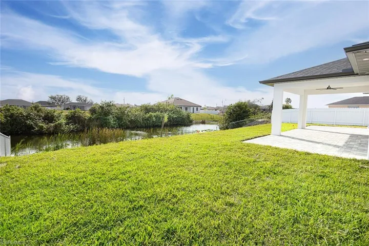 View of yard featuring a patio area, ceiling fan, and a water view