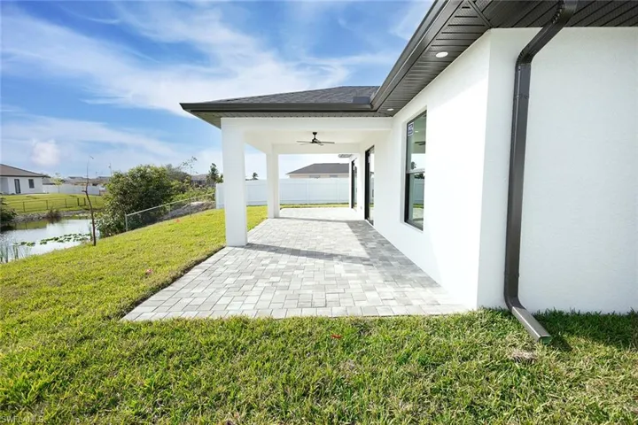 View of patio / terrace with ceiling fan and a water view