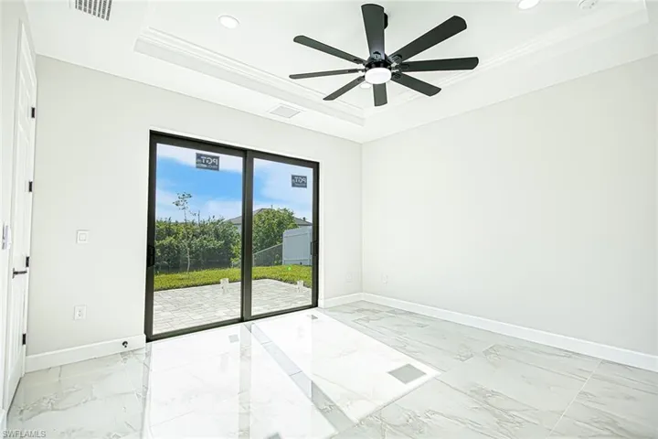 Spare room with a raised ceiling, ceiling fan, and ornamental molding