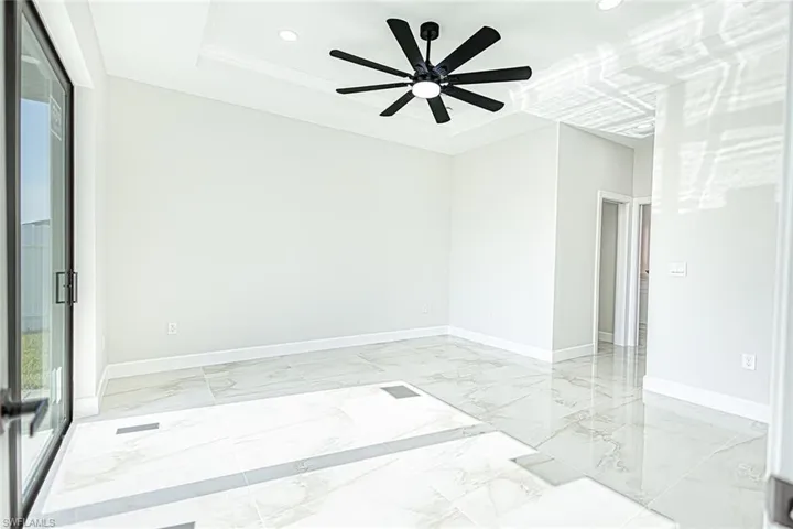 Spare room featuring ceiling fan, a raised ceiling, and crown molding