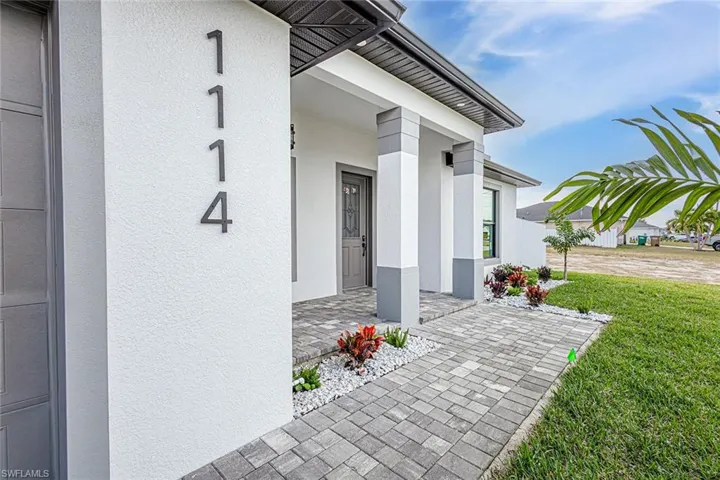 Doorway to property featuring a lawn