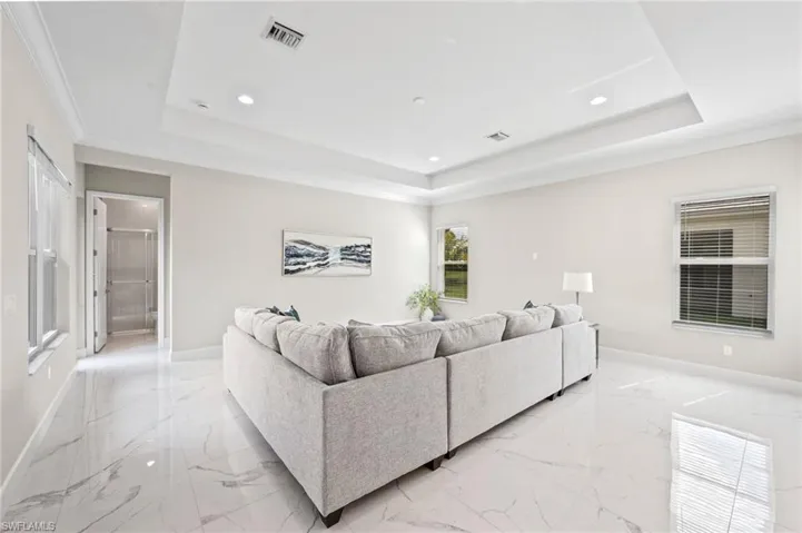 Living room with ornamental molding and a tray ceiling