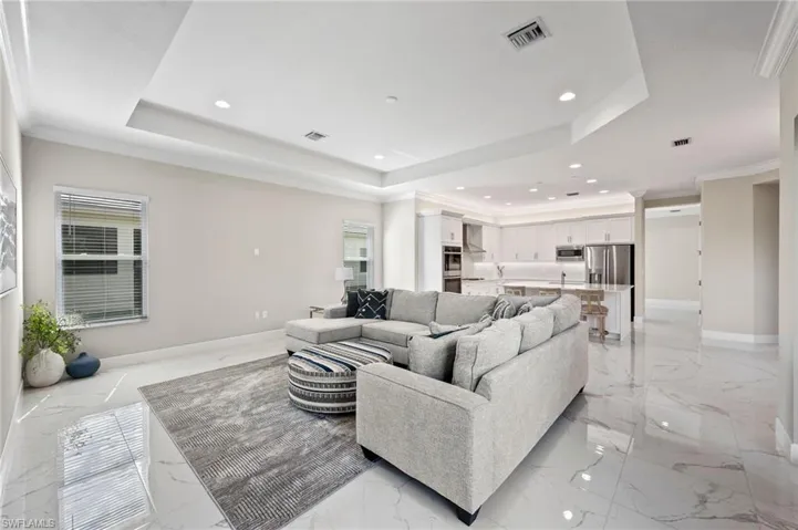 Living room featuring ornamental molding and a raised ceiling