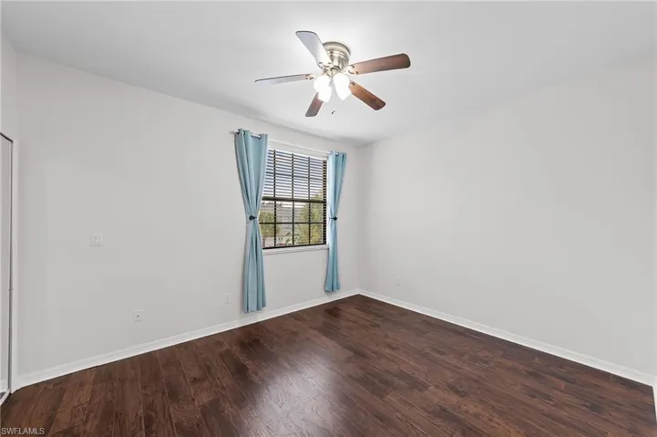 Spare room featuring dark wood-style flooring and a ceiling fan