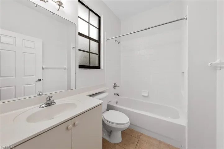 Full bathroom with vanity, shower / bath combination, and light tile patterned floors