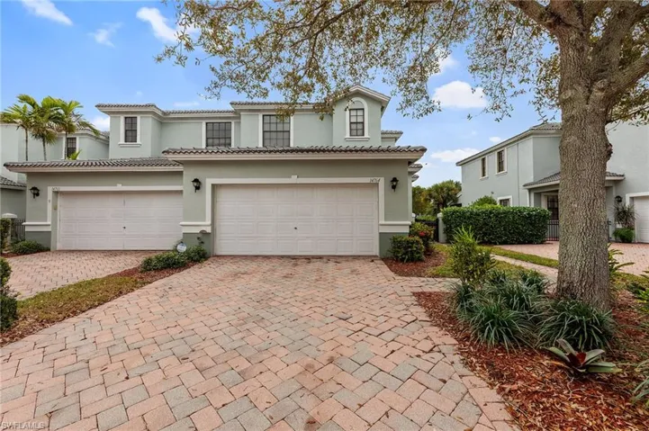 Mediterranean / spanish home featuring a garage, decorative driveway, stucco siding, and a tile roof