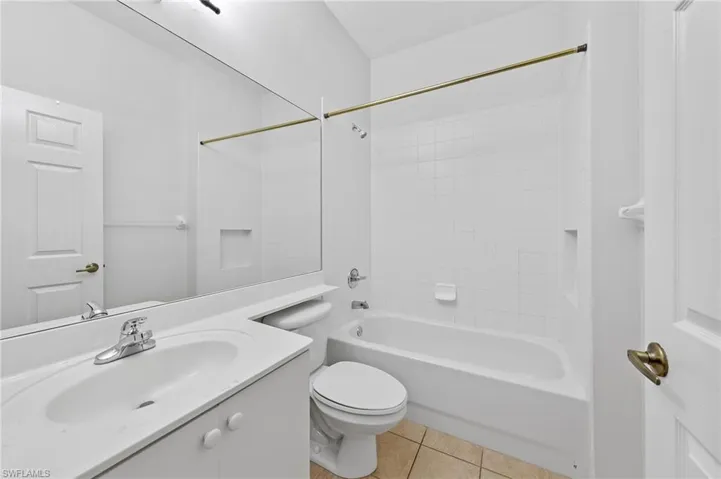 Bathroom featuring vanity, shower / washtub combination, and light tile patterned floors
